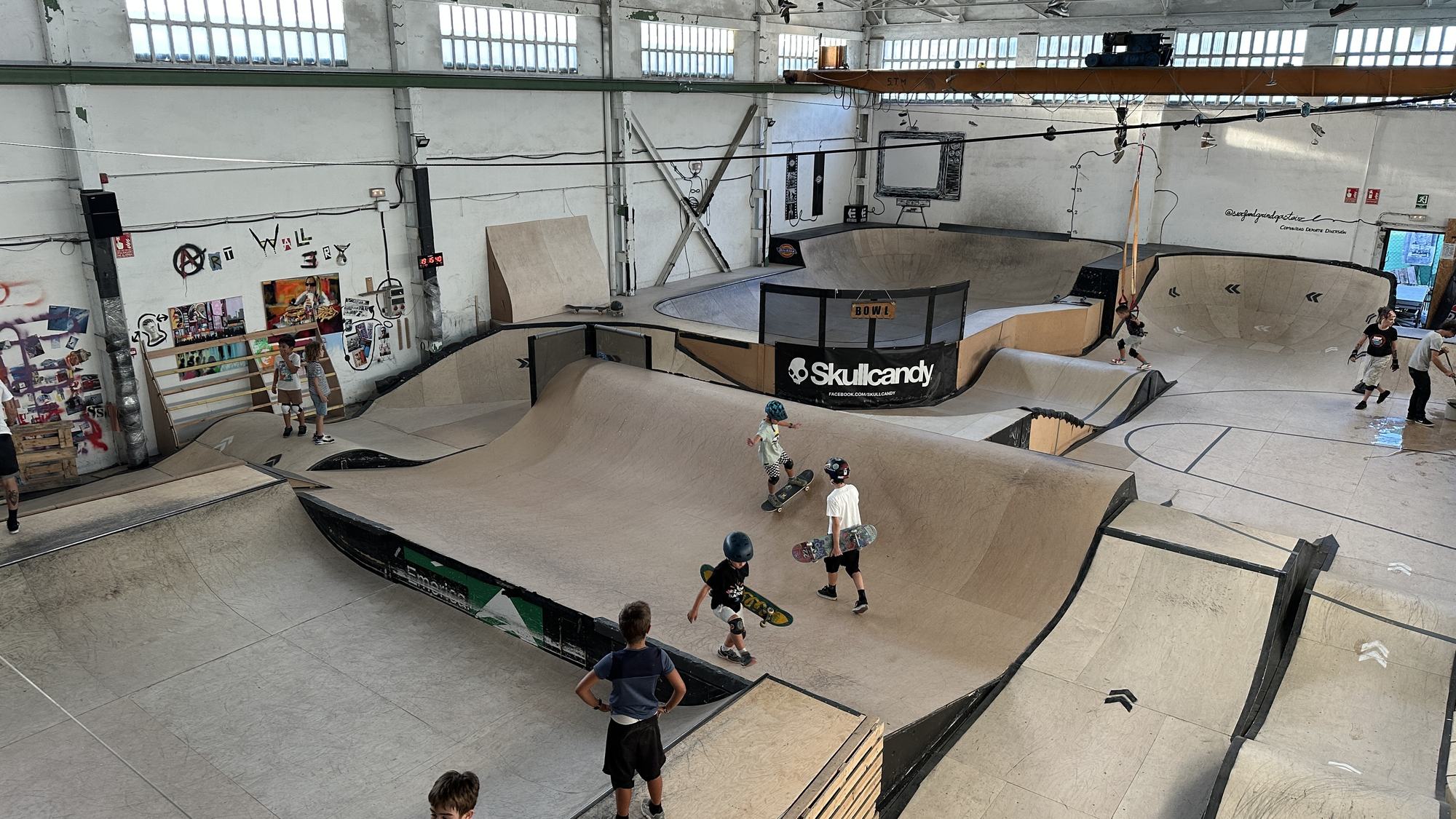 Txikis con casco patinando por el skatepark cubierto durante un campus de Surf & Grind Gasteiz