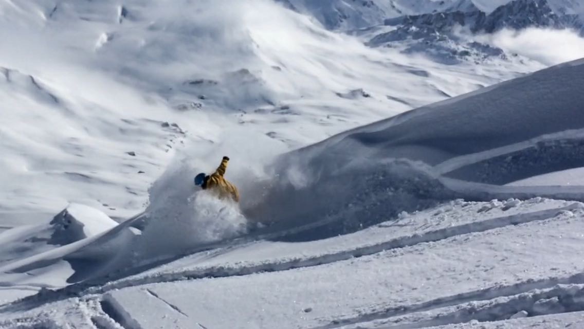 Rider levantando una cortina de nieve polvo en una ladera del Pirineo